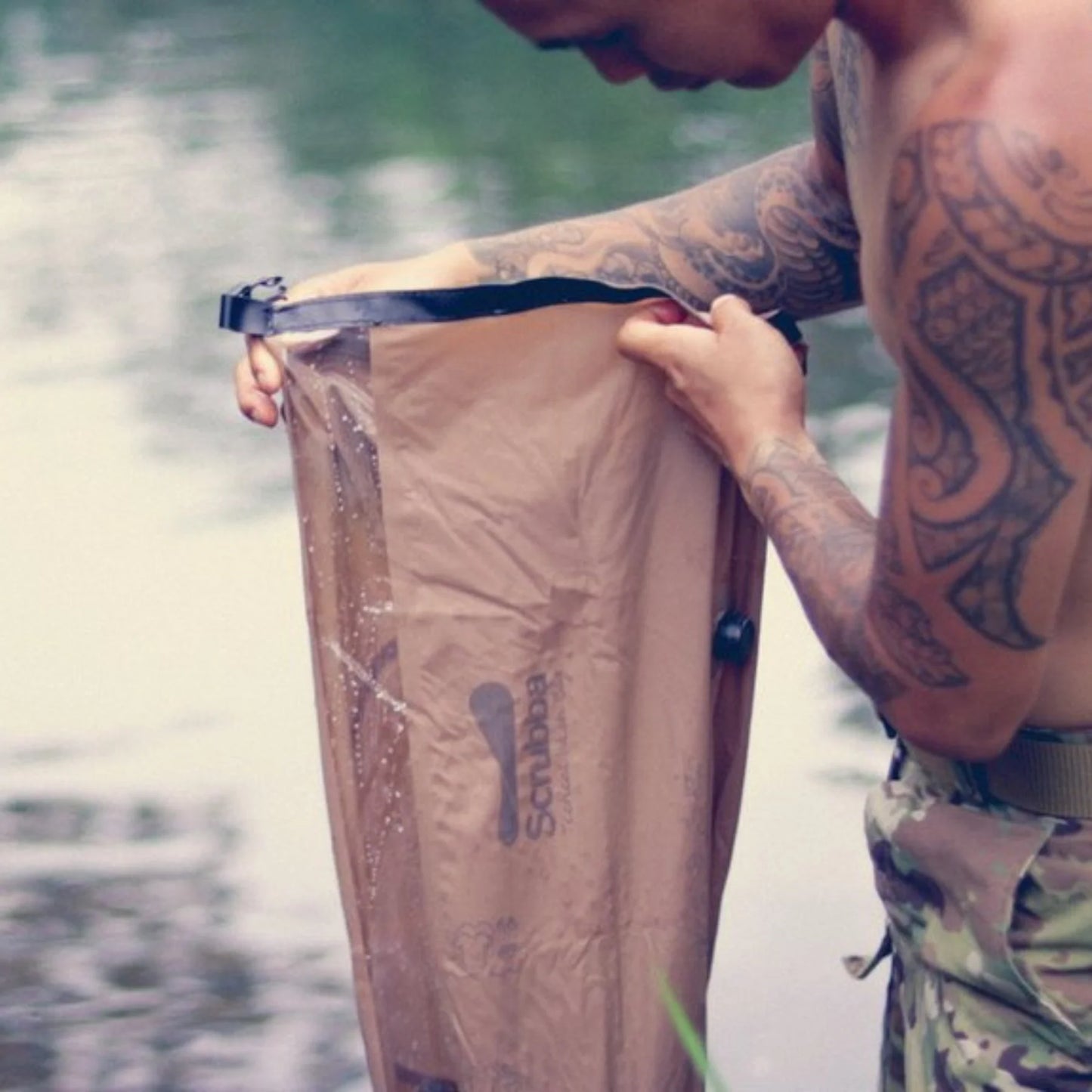 Man using Scrubba Tactical Wash Bag checking water level